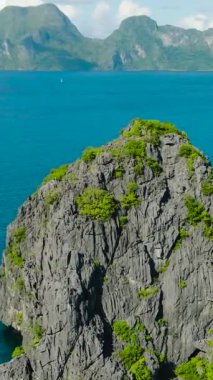 İkiz Kayalar 'da muhteşem kireçtaşı kayaları. Miniloc Adası. Denizin üzerinde tekneler. El Nido, Filipinler. Palawan 'da. Dikey görünüm.