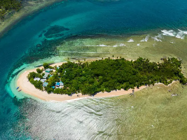 San Victor Adası 'nın etrafı beyaz kumsalla çevrili. Turkuaz su dalgalar halinde güneş ışığıyla yansıtılır. Mindanao, Filipinler. Seyahat ve yaz konsepti.