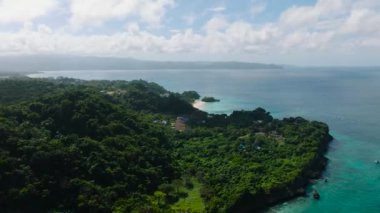 Tekneler turkuaz suyun üzerinde akıyor. Mavi gökyüzü ve bulutlar. Boracay, Filipinler.
