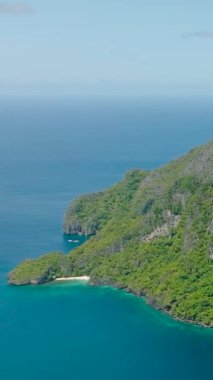 Beyaz kumlu plajları ve mavi denizi olan Cadlao Adası. El Nido. Palawan, Filipinler. Dikey görünüm.