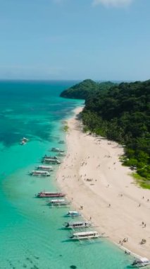 Puka Shell Sahili 'nde beyaz kumlar ve kıyılarda yüzen tekneler. Boracay, Filipinler. Dikey görünüm.
