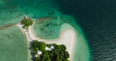 Turkuaz okyanus suyu ve dalgalı beyaz kumsal manzarası. Buenavista Adası. Samal, Davao. Filipinler.