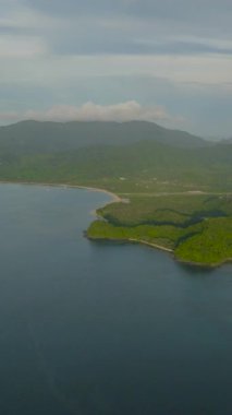 Plajları olan tropik bir ada. Kıyıya yakın tekneler ve mavi deniz. El Nido, Filipinler 'deki Palawan. Dikey görünüm.