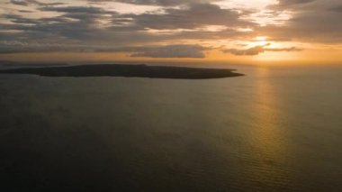 Carabao Adası üzerindeki bulutların ardında güzel bir günbatımı. Romblon, Filipinler.