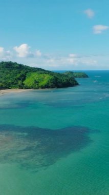Kumsalda yeşil deniz suyu ve okyanus dalgaları. Duli Sahili. El Nido, Palawan. Filipinler. Dikey görünüm.