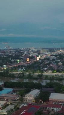 Cagayan de Oro 'da ışıkları olan binalar ve köyler. Mindanao, Filipinler. Dikey video.