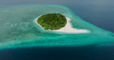 Mantigue Adası 'nda yemyeşil ağaçlar. Turkuaz su ve beyaz kumlu plajlar. Camiguin, Filipinler.