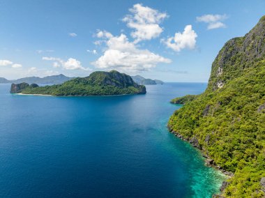 Cadlao ve Helikopter Adası 'ndaki mavi deniz. Mavi gökyüzü ve bulutlar. El Nido, Palawan. Filipinler.