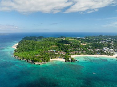 Beyaz kumlu sahil beldeleri ve şeffaf deniz suyunun üzerinden geçen turist botu. Boracay Adası. Filipinler.