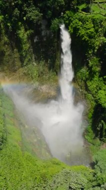 Hikong Bente Şelalesi üzerindeki güzel gökkuşağı dağ ormanları, yağmur ormanları ve yeşil ağaçlarla çevrili. Sebu Gölü. Mindanao, Filipinler. Dikey görünüm.