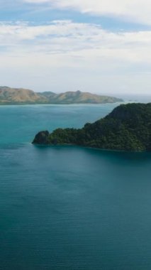 Coron 'da mavi denizle çevrili adalar. Mavi gökyüzü ve bulutlar. Palawan, Filipinler. Dikey görünüm.
