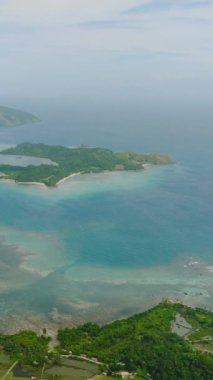 Turkuaz deniz suyu ve mercanları olan tropik bir ada. Santa Fe, Tablas, Romblon 'daki Paddy çiftliği. Filipinler. Dikey görünüm.