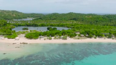 Turkuaz deniz suyu ve dalgalar kumlu sahile çarpıyor. Santa Fe, Tablas, Romblon. Filipinler.
