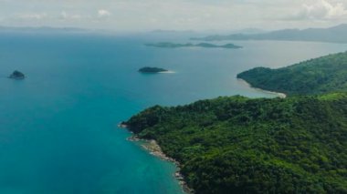 Mercan resifli mavi denizi olan tropik bir ada. Mavi gökyüzü ve bulutlar. El Nido, Palawan. Filipinler.