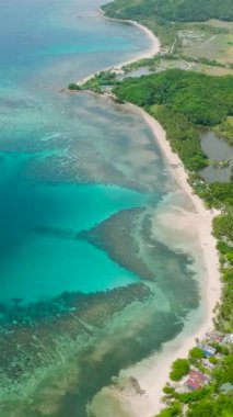 Turkuaz su ve mercan resifleri. Paddy çiftliği ve Santa Fe, Tablas, Romblon 'daki evler. Filipinler. Dikey görünüm.