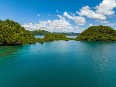 Göl kenarındaki turkuaz su çok güzel. Mavi gökyüzü ve açık bulutlar. Tinago Adası. Mindanao, Filipinler.
