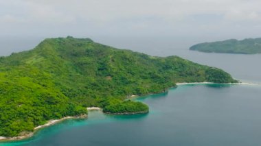 Yeşil bitkileri ve ağaçları olan tropik bir ada. Alad Adası 'nda mavi deniz. Romblon, Filipinler.