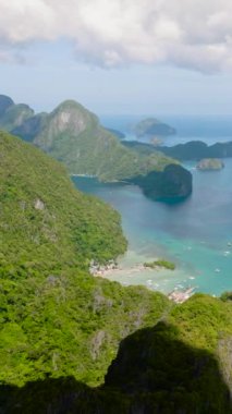 Plajları ve evleri olan El Nido kıyı kasabası. Mavi gökyüzü ve bulutlar. Palawan 'da. Filipinler. Dikey görünüm.