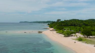 Mercanlı şeffaf turkuaz deniz suyu. Santa Fe, Tablas, Romblon 'daki beyaz kumsalda dalgalar. Filipinler.