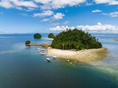 Beyaz kum plajı ve tekneleri olan Hiyoran Adası. Britanya Adaları Grubu. Surigao del Sur, Filipinler.