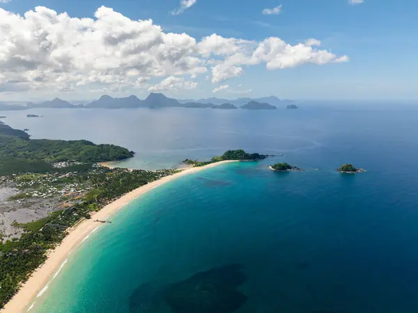 Nacpan Sahili 'nde krem renkli kumlar. Mavi gökyüzü ve bulutlar. El Nido, Filipinler.