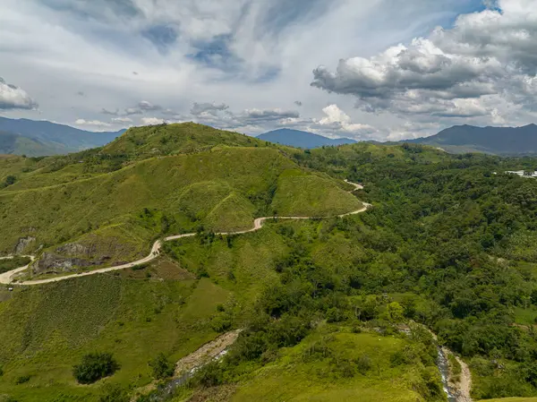 Tropik dağ vadisi ve dağ asfaltı yolu. Nehrin üzerinde akan suyu olan yağmur ormanları. Mindanao, Filipinler.