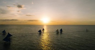 Yelkenlilerin ve denizlerin üzerinde bulutlu gün batımı. Boracay, Filipinler.