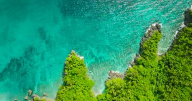 Okyanus dalgaları kayalık kıyı şeridine çarpıyor, turkuaz su ve mercanlar. Carabao Adası. San Jose, Romblon. Filipinler.