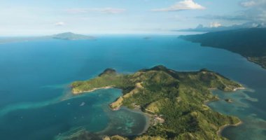Tropik ada, gök mavisi su mercan kayalıklarını ve mercan adalarını çevreledi. Uyuyan Dinozor Adası. Mati, Davao Oriental. Filipinler.