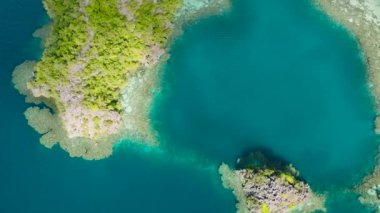 Coron, Palawan 'da turkuaz gölün üzerinden geçen bir tekne. Filipinler.