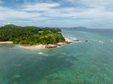 Kıyı bölgesinde turkuaz deniz dalgaları, kayalar ve beyaz kumlar. Santa Fe, Tablas, Romblon. Filipinler.