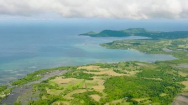 Tropik adanın kıyısındaki turkuaz deniz suyuyla birlikte tarım arazisinin havadan görünüşü. Tablolar Adası. Romblon, Filipinler.