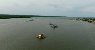 Nehrin üzerinde geleneksel balıkçı tekneleri, mavi gökyüzü ve bulutlarla tropik bir manzara. Bislig, Surigao del Sur. Filipinler.