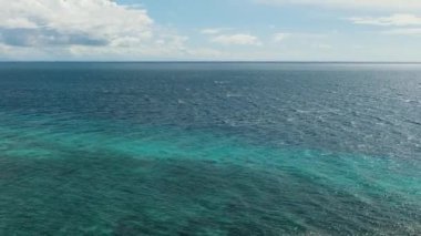 Mercan resifli deniz burnu, açık mavi gökyüzünün altında derin mavi deniz. Okyanus silueti. Siquijor, Filipinler.