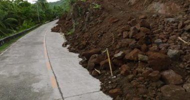 Şiddetli yağış nedeniyle dağ heyelanı. Yolun sağ tarafındaki çamurlu abd kayaları. Filipinler.