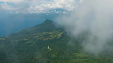 Dağlar yağmur ormanlarıyla, ağaçlar ve bulutlarla kaplı mavi gökyüzü. Camiguin Adası. Filipinler.