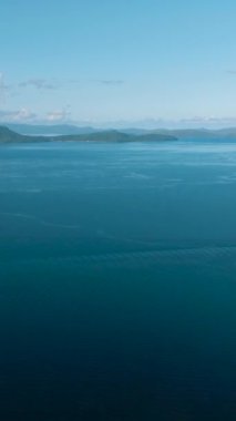 Güzel mavi deniz ve tropikal adalar. Açık gökyüzü ve bulutlar. Mindanao, Filipinler. Dikey görünüm.