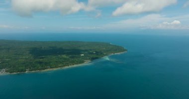 Mavi gökyüzü ve bulutların altında tropikal adanın etrafında mavi deniz manzaralı bir deniz manzarası. Talikud Adası. Davao, Filipinler.