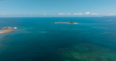 Derin mavi denizde beyaz kumlu tropik bir ada. Filipinler, Surigao del Sur 'daki Jobo Adası.