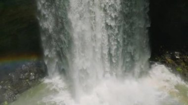 Dağlık ormanla birlikte gökkuşağı ile birlikte şelaleler. Hikong Alo Şelalesi. Sebu Gölü. Mindanao, Filipinler. Yavaş çekim.