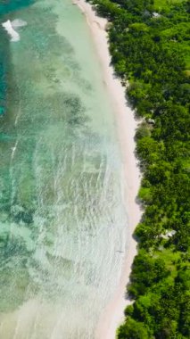 Açık okyanus dalgaları ve mercanları olan tropik bir sahil. El Nido, Palawan. Filipinler. Dikey görünüm.