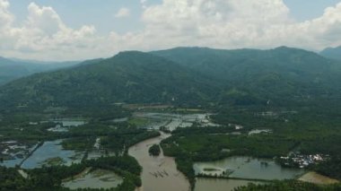 Mavi gökyüzü ve bulutların altında çiftlik ve balık çiftliği. Mindanao, Filipinler.