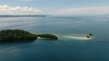 Kumlu plajı ve mavi denizi olan tropik bir ada. Millari Adası. Mindanao, Filipinler.