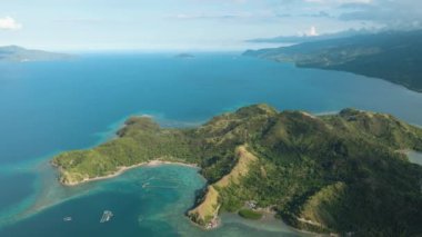 Açık okyanusta plajı olan tropik bir ada. Kıyı şeridine yakın turkuaz su. Mati, Davao Oriental. Filipinler.