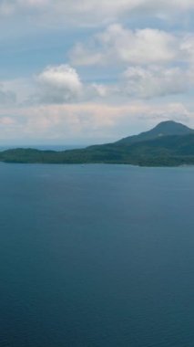 Mavi gökyüzünün altında güzel mavi deniz ve Camiguin Adası 'nda bulutlar. Filipinler. Dikey video.