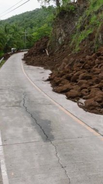 Dağ uçurumundan gelen toprak kaymaları dağ yolunu kapatıyor. Camiguin, Filipinler. Dikey video.