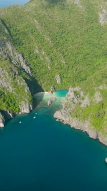 El Nido, Palawan 'daki Cadlao Gölü' nde mavi deniz ve tekneler. Cadlao Adası. Filipinler. Dikey görünüm.