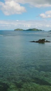 Busuanga 'da saydam deniz suyu ve mercanlar. Mavi gökyüzü ve bulutlar. Palawan 'da. Filipinler. Dikey görünüm.