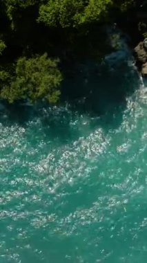 Turkuaz su ve okyanus dalgalarıyla kıyı şeridi manzarası. Samal Adası. Davao, Filipinler. Dikey görünüm.
