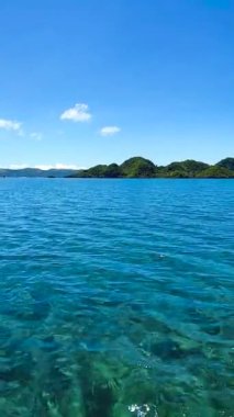 Tropik ada manzarası. Mavi gökyüzü ve bulutlar. Tagana-an, Surigao del Norte. Filipinler. Dikey görünüm.
